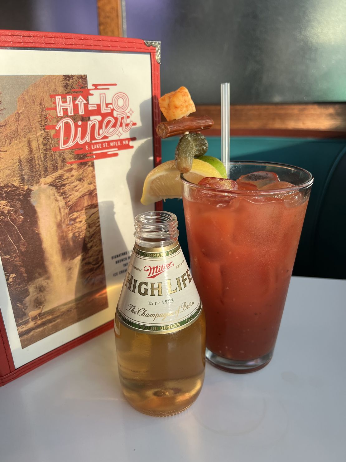 El 'Hi-Lo Bloody' en el Hi-Lo Diner de Minneapolis, Minnesota. La bebida incluye algunas especias africanas únicas, una salsa Worcestershire vegana casera y está ensartada con una cuajada de queso de búfalo muy no vegana y un trozo de Slim Jim.