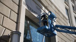 Un trabajador retira el cartel de la Agencia de Estados Unidos para el Desarrollo Internacional de su sede el 7 de febrero de 2025 en la ciudad de Washington.