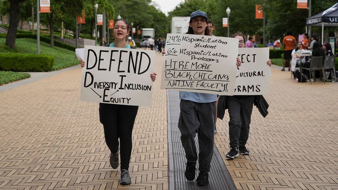 Ashley Awad and Jules Lattimore participate in a protest to defend diversity, equity and inclusion at the University of Texas, in April 2023. 