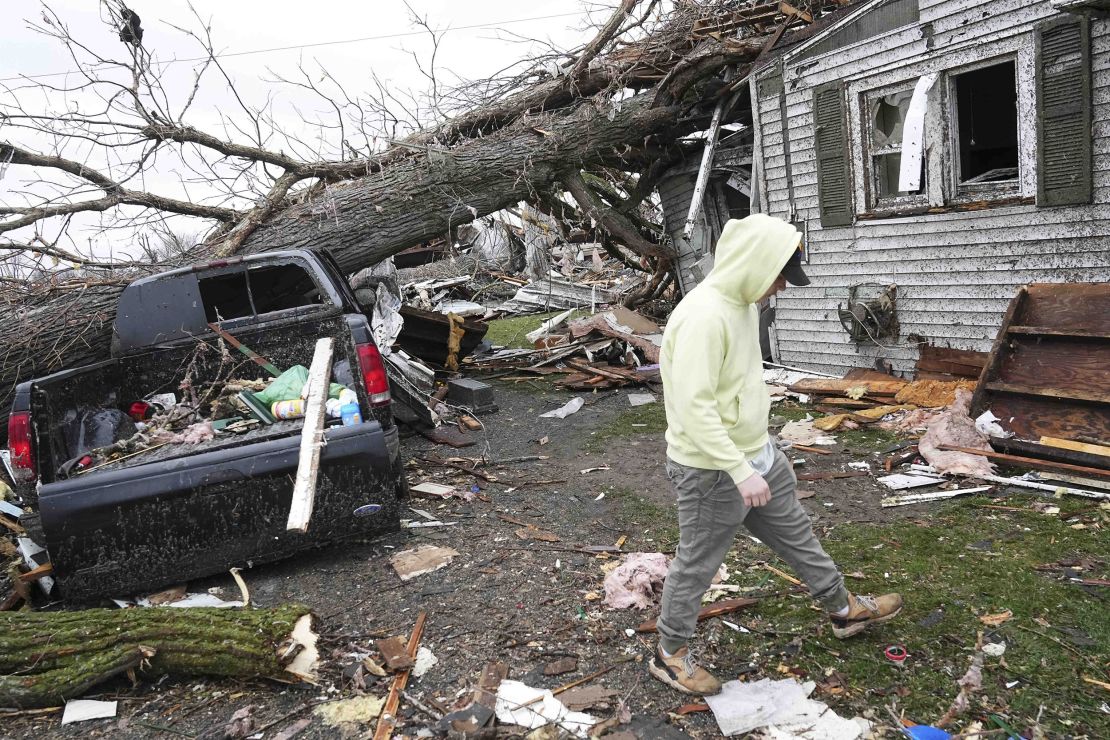 Tyler Schmitt helps clean up his brother's home after a tornado struck Lakeview, Ohio, Thursday.