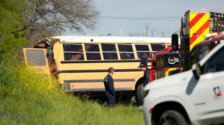 Officials look at a fatal school bus crash on SH 21 near Caldwell Road Friday March 22, 2024.