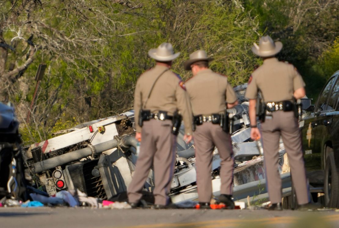 State troopers look at a vehicle involved in the crash.
