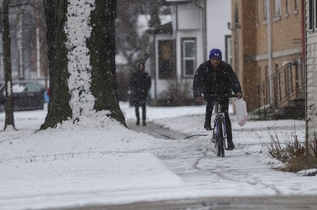 A cyclist rides on a snow-covered sidewalk on Wednesday, April 3, 2024, in Green Bay, Wisconsin.