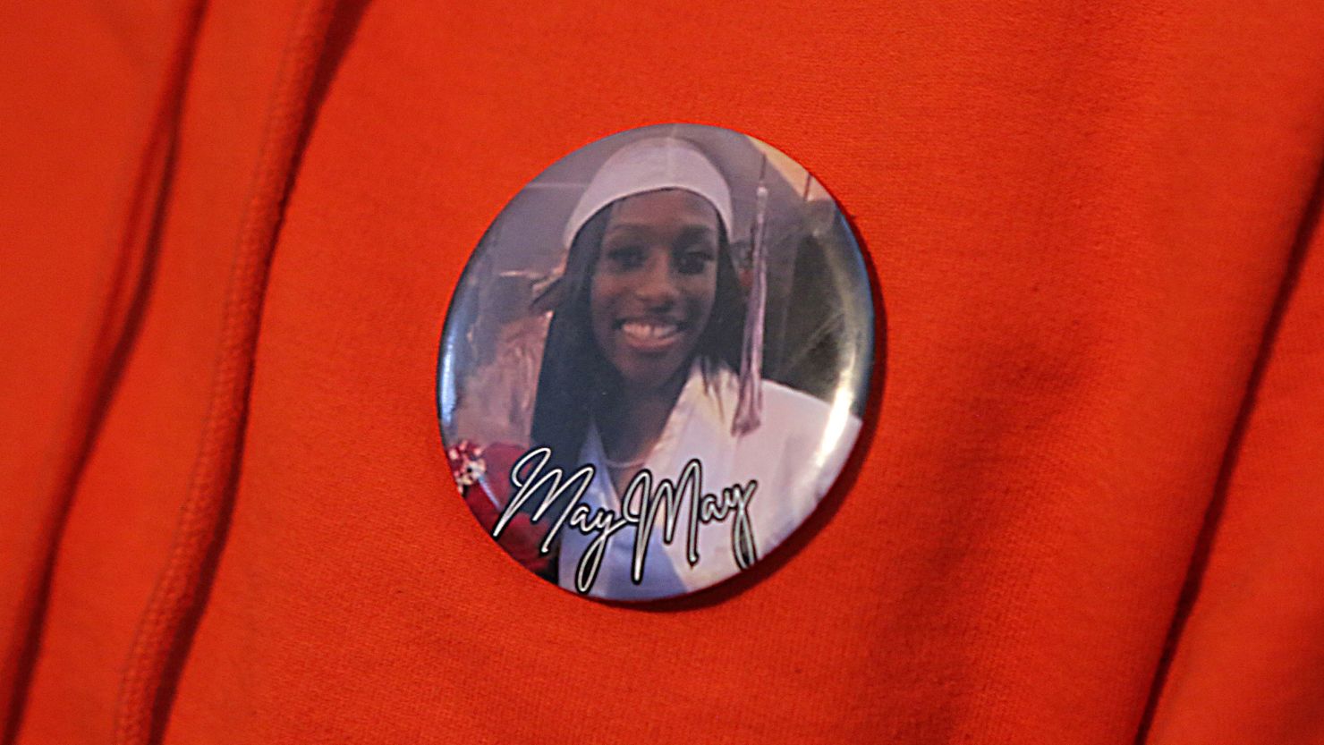 Charlotte De Silva Davis wears a pin with a picture of her niece Camay De Silva's graduation picture on it.