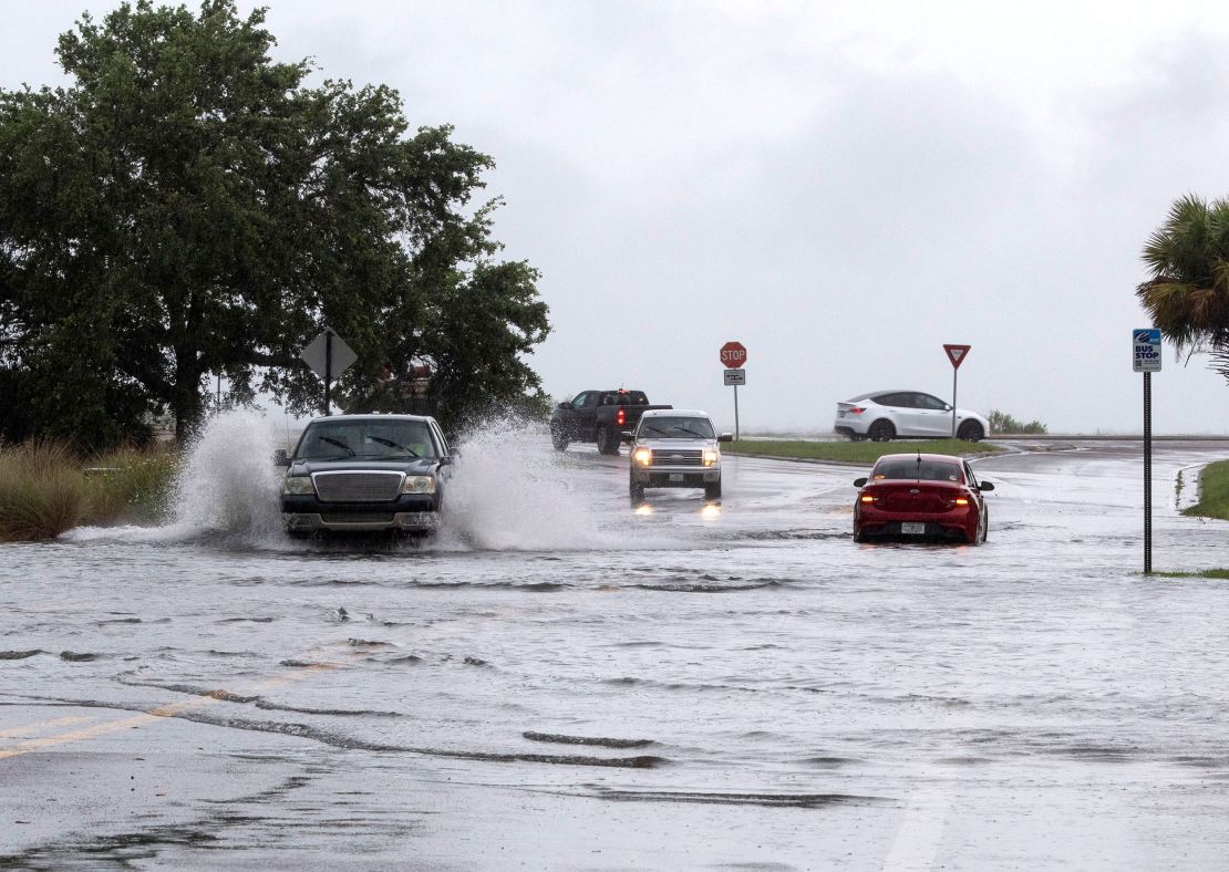Vehicles drive through floodwaters in Pensacola, Florida, on Monday.