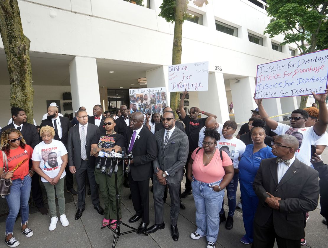 DeAsia Harmon is seen to the left of attorney Ben Crump, center, during a Monday news conference outside the Milwaukee hotel where D’Vontaye Mitchell died in June.