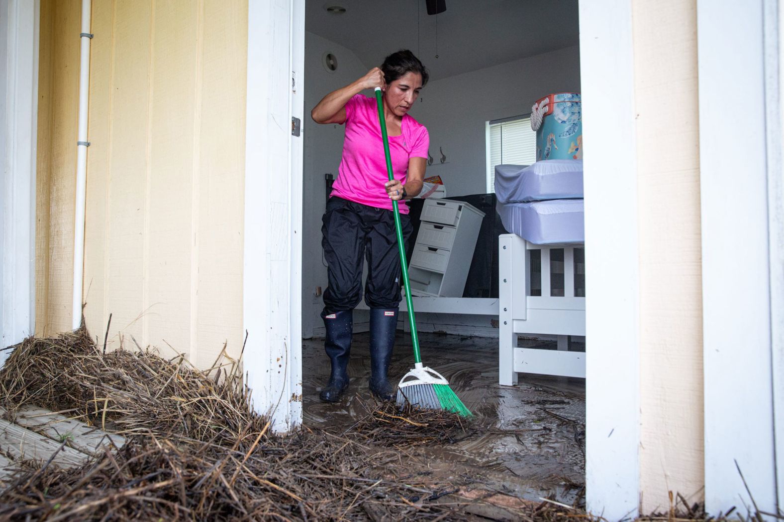 Elsa Gonzales sweeps mud and debris out of her flooded house near Matagorda, Texas, on Monday.