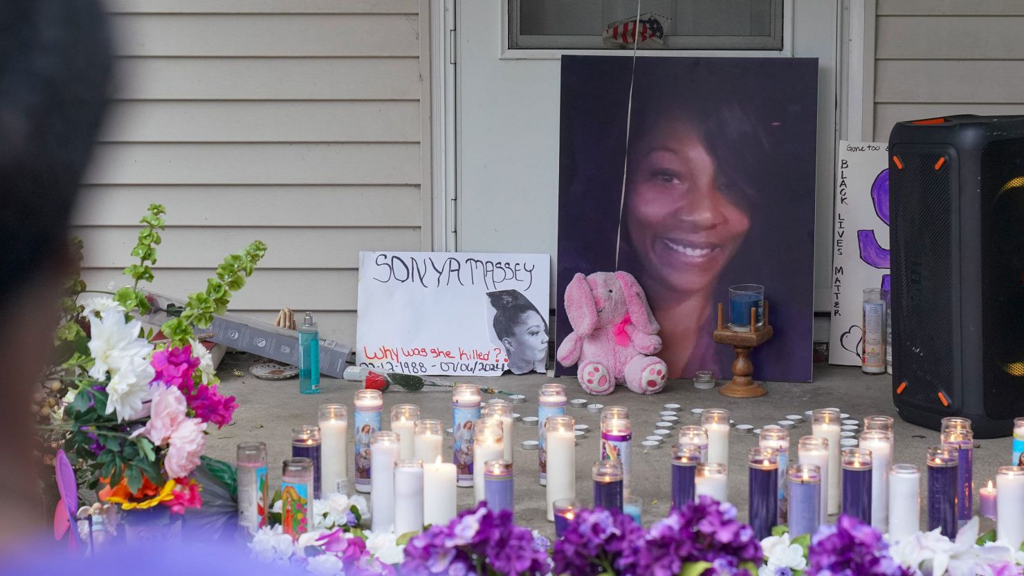 A photo of Sonya Massey, flowers and candles were displayed on the front porch of her home after her death last year.