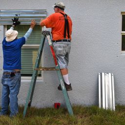 Habitat for Humanity construction field manager Danny Bilyeu, left, and volunteer Mike Sanderson, install hurricane storm panels on new Habitat for Humanity home on Gladstone St. in Sarasota Tuesday morning, in preparation for Potential Tropical Cyclone 9.