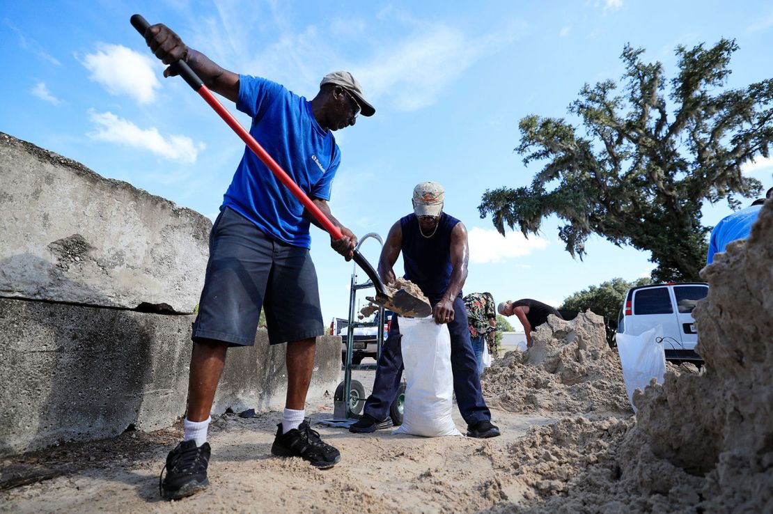 Herman Mccrimager schaufelt mit seinem Freund Connell Crooms am Dienstag, den 24. September, Sand, um Säcke bei Woerner Turf and Landscaping Supply in Jacksonville, Florida, zu füllen.