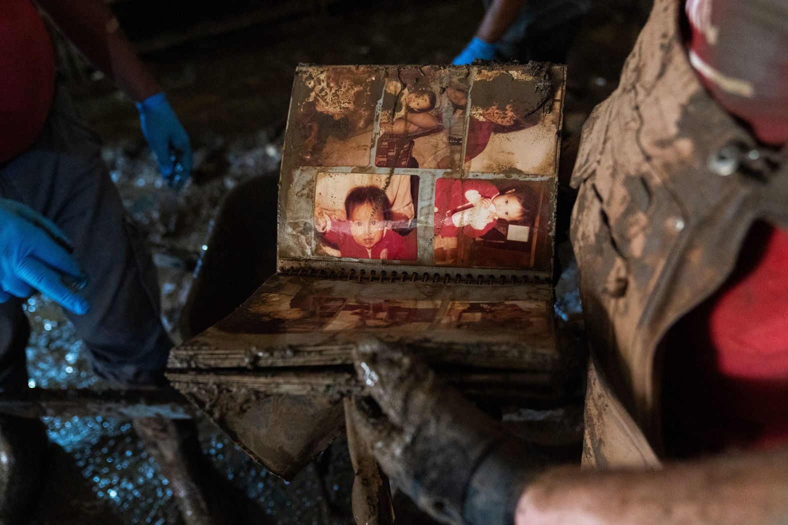 Van Hutchins, right, hands Dennis Rector a family photo album that survived the flooding of his wife's business, the Penland & Sons Department Store, in Marshall, North Carolina.