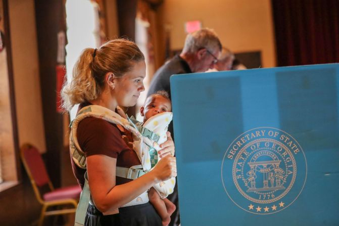 Jordan Dunson casts her ballot Tuesday while holding her baby at the First Presbyterian Church in Savannah, Georgia.