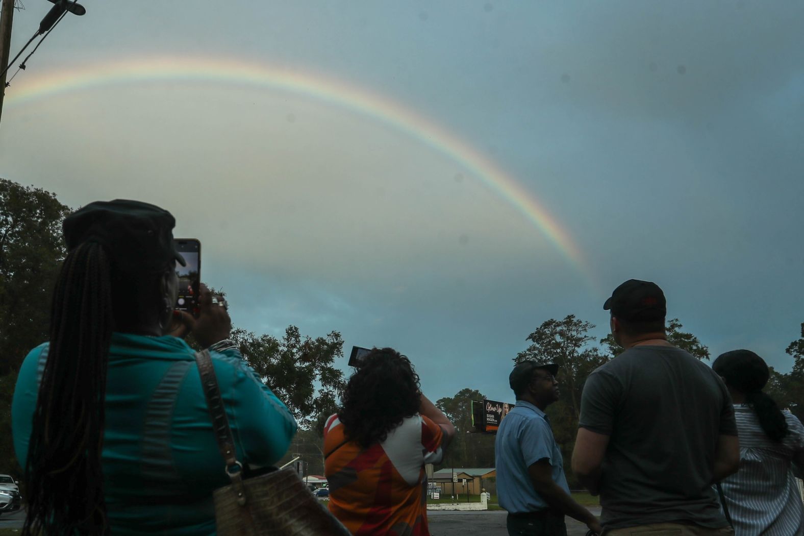 Voters take photos of a rainbow as they wait in line outside a polling location in Garden City, Georgia, on Tuesday.