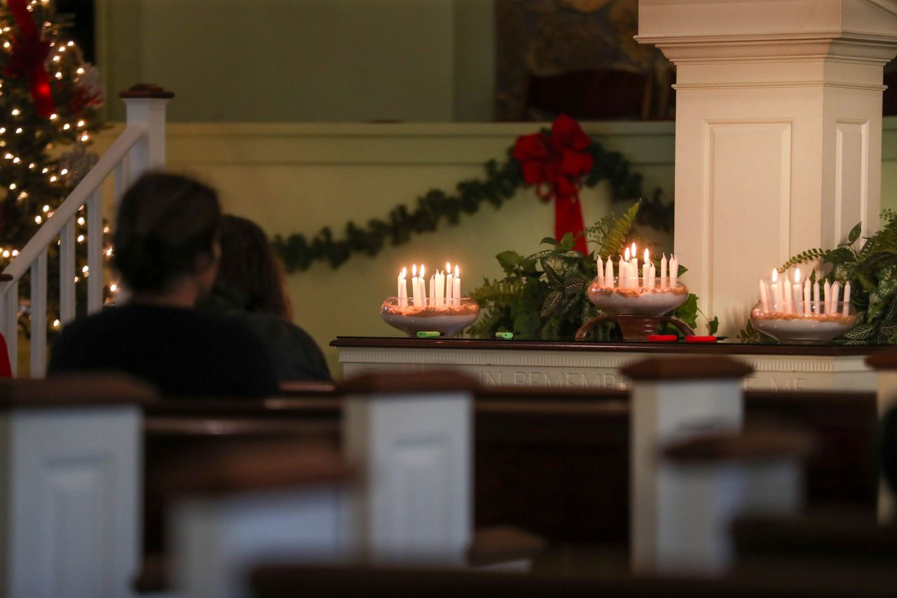 Candles flicker on the altar as attendees sit during a silent vigil to honor former President Jimmy Carter at Maranatha Baptist Church in Plains, Georgia, on Monday.