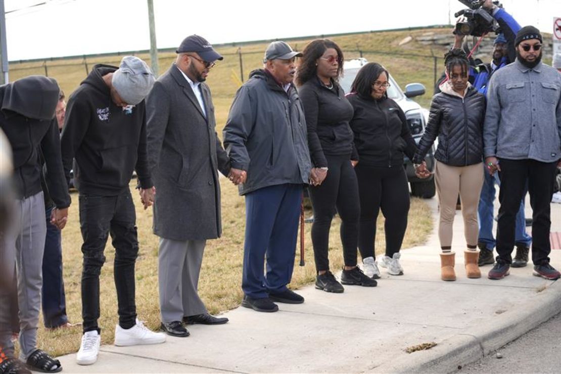 A prayer circle forms after a group displaying swastika flags was seen demonstrating on an Interstate 75 overpass in Evendale on February 7, 2025.