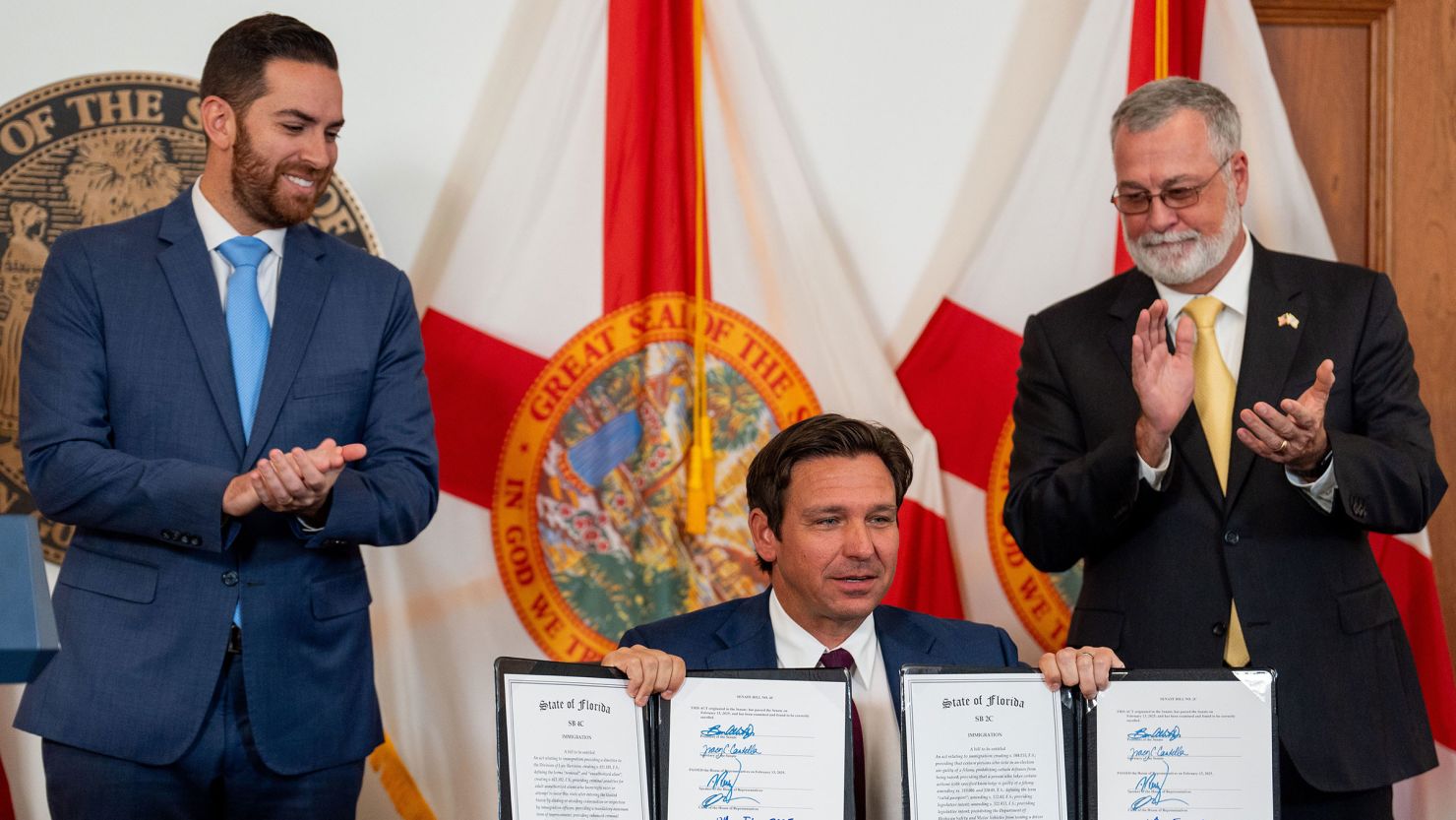Floria Gov. Ron DeSantis signs immigration legislation, with state Senate President Ben Albritton and Speaker of the House Danny Perez by his side on February 13, 2025.