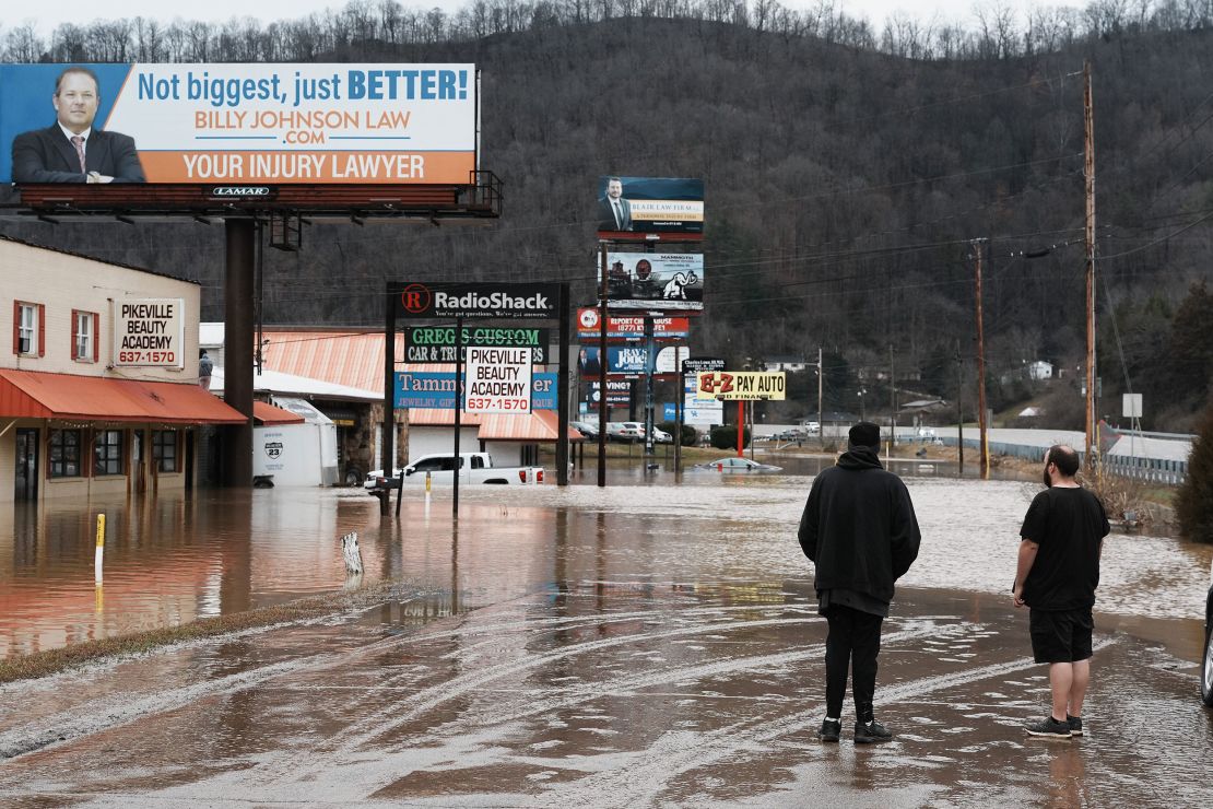 Passersby looked on as water crept into businesses during a major flooding event in Pikeville, Kentucky on Sunday.