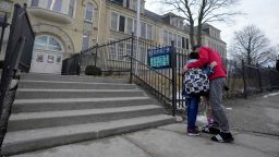Miguel Ortega hugs his son and daughter (behind) before they go into school at Trowbridge Street School of Great Lakes Studies in Milwaukee on Friday, Feb. 28, 2025. The Milwaukee Health Department has ordered the school to temporarily close starting Monday after finding “unsafe lead dust levels” within the building.