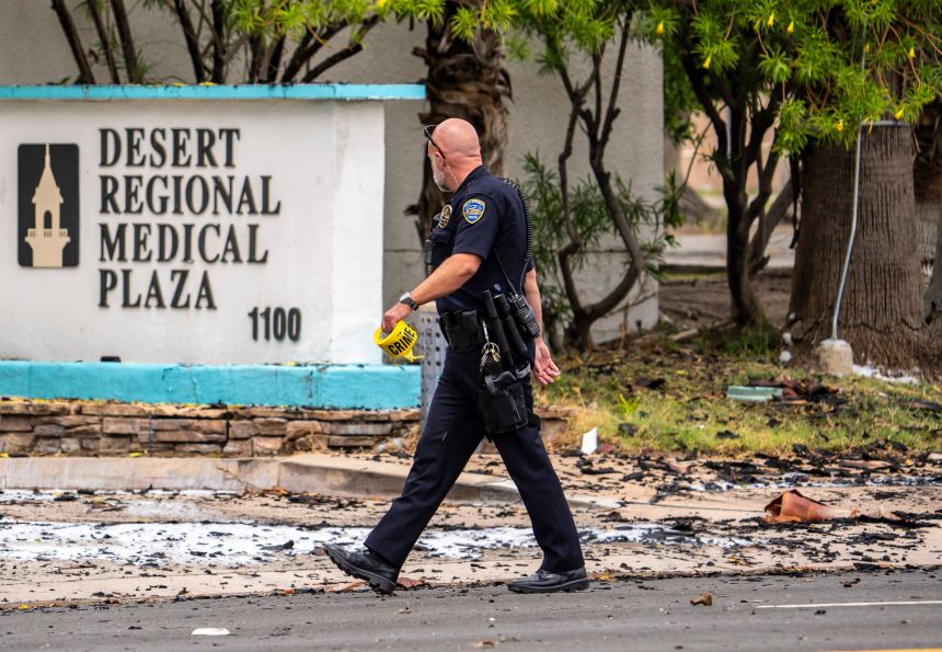 A Palm Springs Police Department officer puts up more caution tape around the scene of an explosion near the American Reproductive Centers clinic in Palm Springs, Calif., Saturday, May 17, 2025.