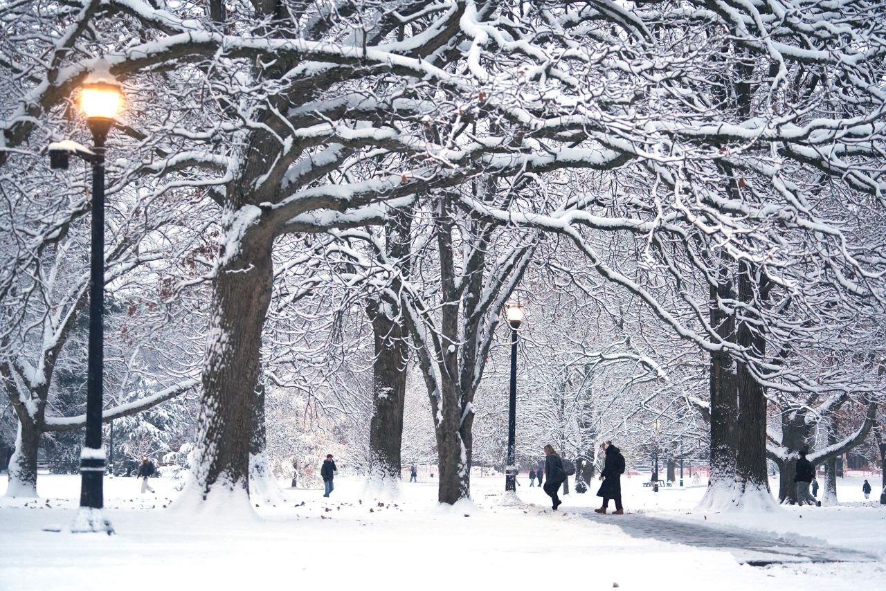 People walk through the winter wonderland of Ohio State University’s Mirror Lake and the Oval after several inches of snow fell early in the morning Tuesday, Dec. 2, 2025.