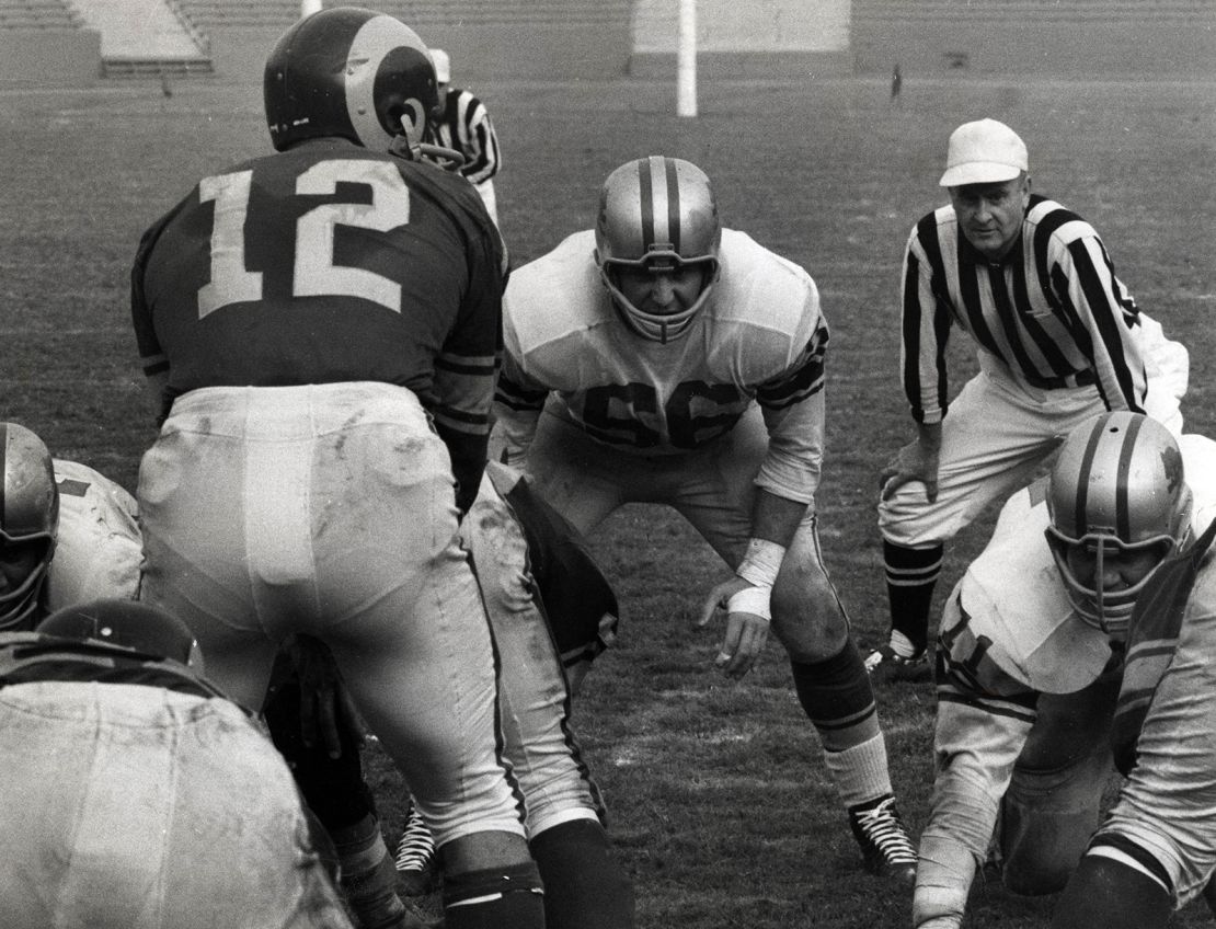 Schmidt (56) lines up as Los Angeles Rams quarterback Zeke Bratkowski (12) prepares to snap the ball against the Detroit Lions at Los Angeles Memorial Coliseum on October 29, 1961.