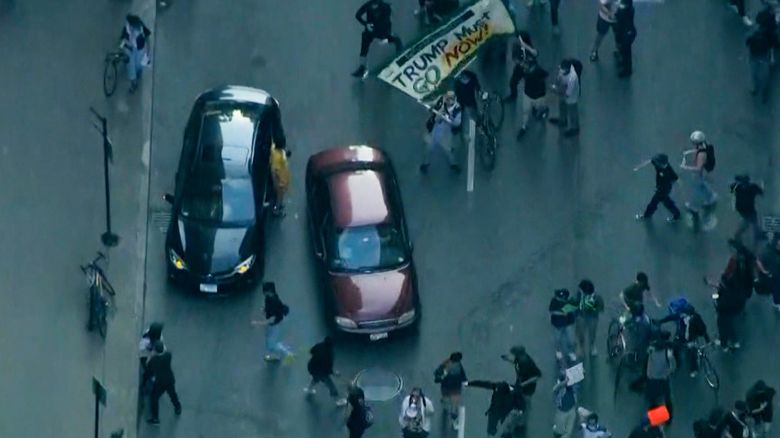Video shows a car driving through the protest near Federal Plaza in downtown Chicago. The car appears to push a few sign holders before continuing through the protest and speeding away.