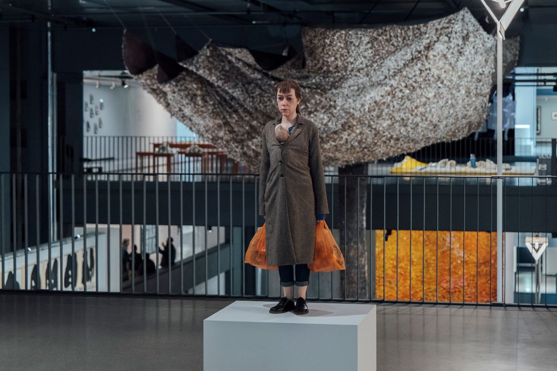 A hyperrealistic sculpture by Ron Mueck and a textile work by Olga de Amaral in the background.