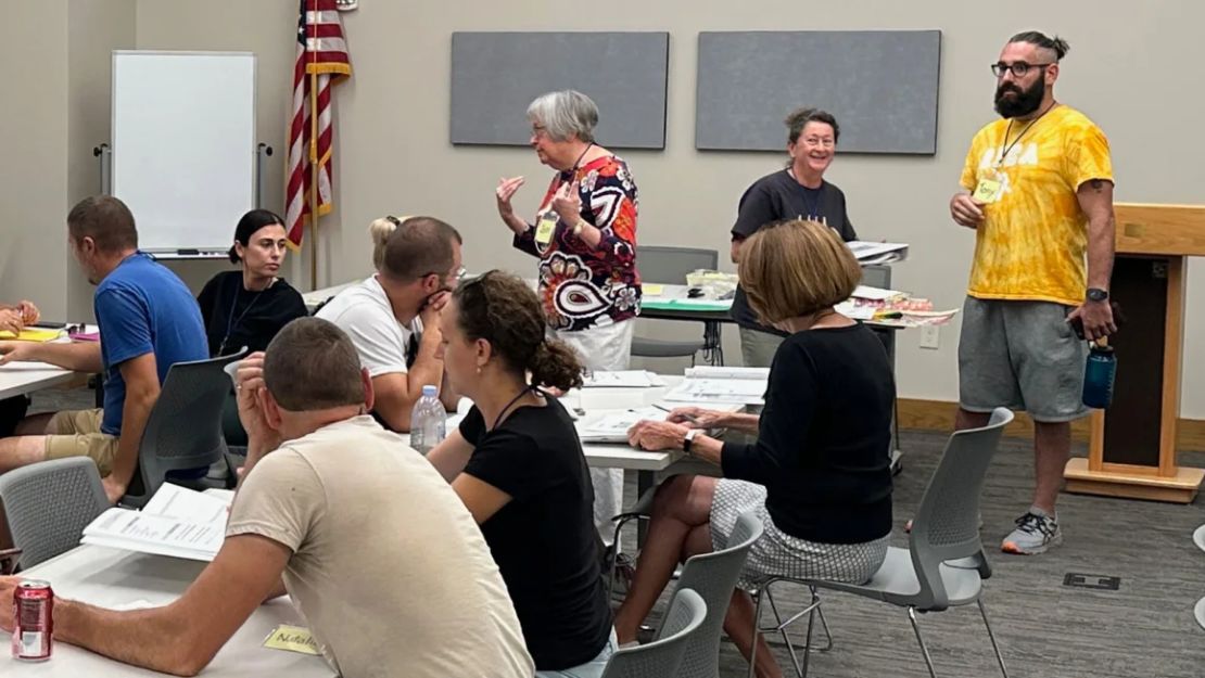 Los voluntarios de la comunidad de Integración e Intercambio de Recién Llegados de Iowa (IA NICE) brindan lecciones de inglés gratuitas a ucranianos en la biblioteca comunitaria de DeWitt