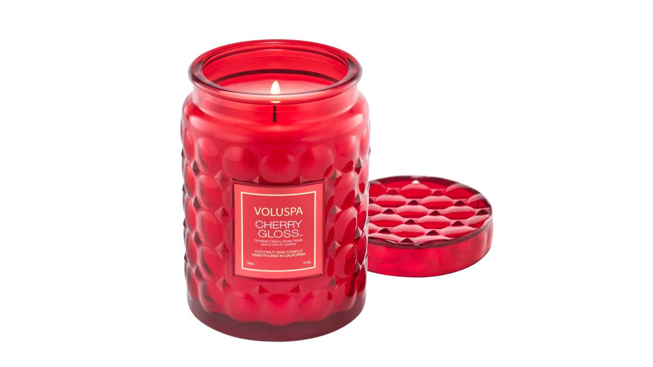 A large candle in a red jar.