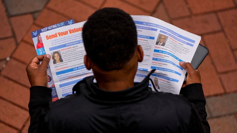 A man reads election materials before voting in Charlotte, North Carolina, on Saturday.