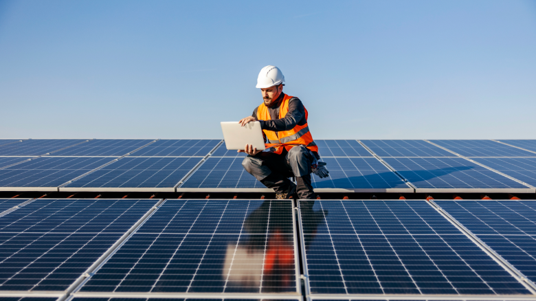 Solar installer tests solar panels on a rooftop.
