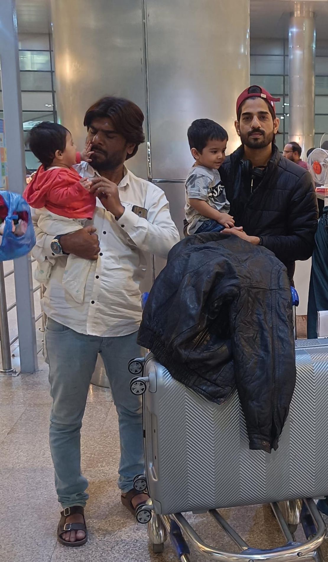 Asfan Mohammed, right, and his brother Imran are pictured with Asfan's children before Asfan left for Russia.