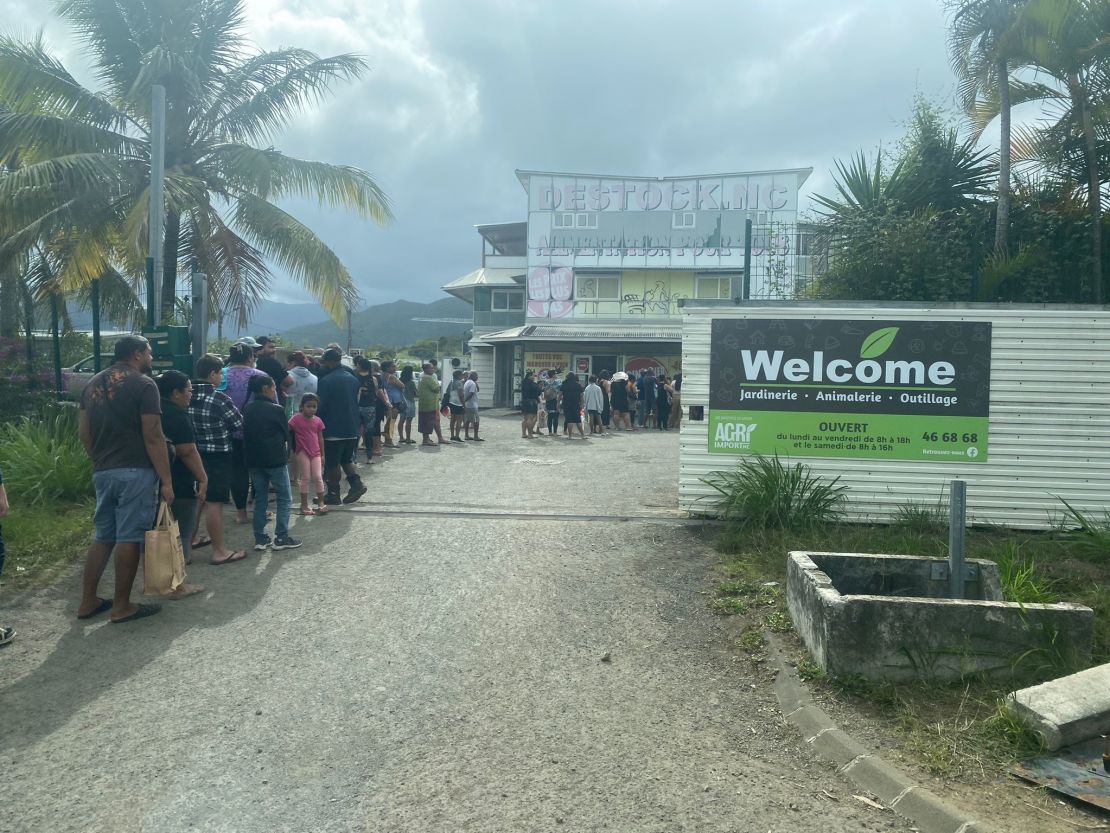 People line up at a store for supplies in New Caledonia, with larger supermarkets nearby burned and looted during the riots on the French territory.