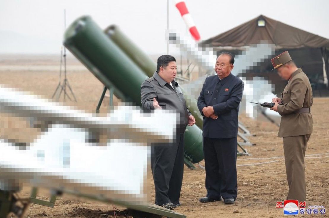 North Korean leader Kim Jong Un speaks with officials as he oversees a test of self-detonating drones, according to state media KCNA. Elements of this image were blurred before their release.