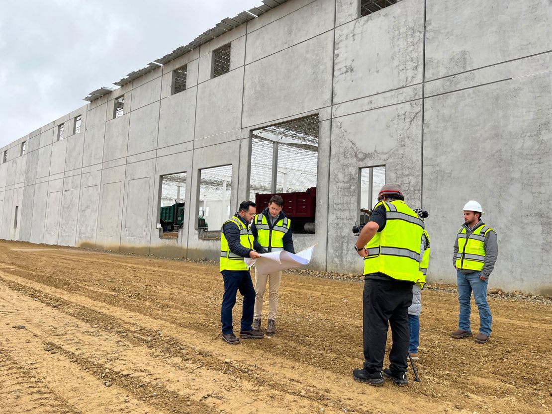 González shows building plans to David Culver at a construction site.