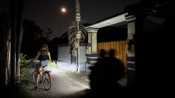 People ride through darkness in Sanur, Bali, as most areas of the Indonesian island, a major tourist hotspot, suffered a major power outage on Friday.