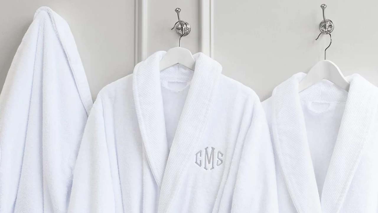 White towel robes hang along a wall.