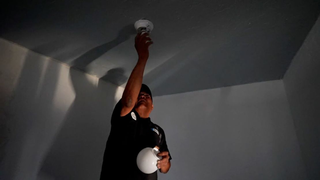 William Lee Tom Jr. screws in a lightbulb at his Navajo Nation home.