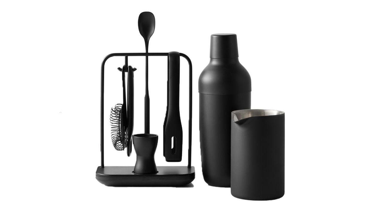 The Williams Sonoma Encore Ultimate bar tools set, including a shaker, mixing cup, jigger, bar spoon, strainer, bottle opener and tongs, on a white background.