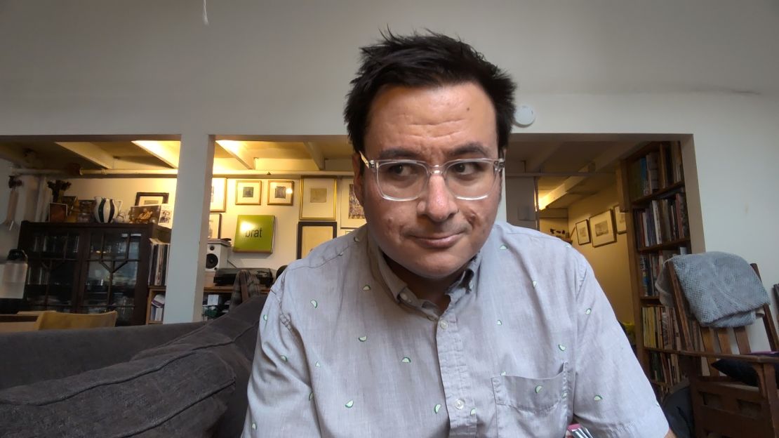 A selfie of the author where he's looking to his right, he's wearing a grey shirt with limes and Charli xcx's Brat album is hanging in the background.