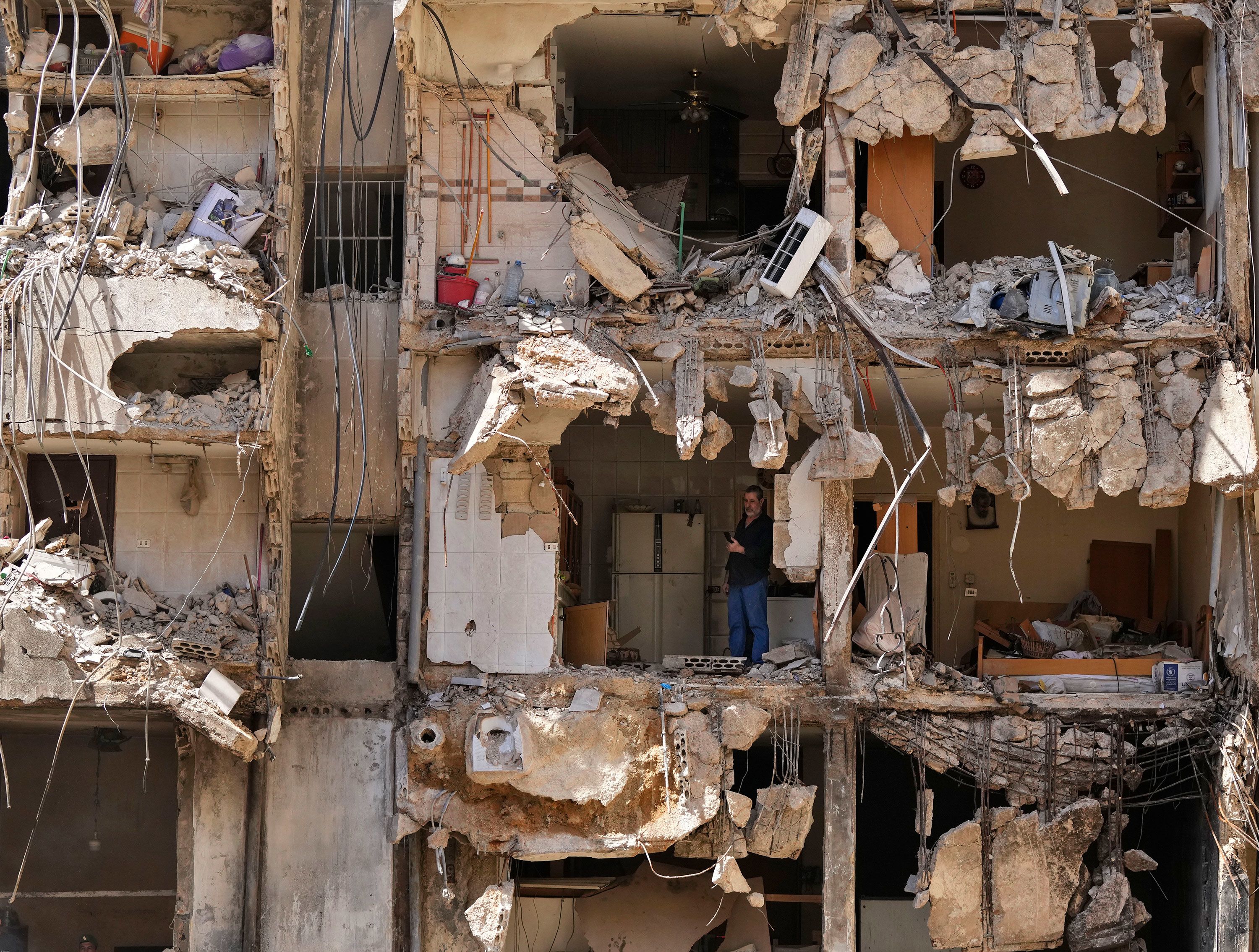 A man watches rescue workers sift through rubble in search of missing people at the site of Friday’s Israeli strike in the southern suburbs of Beirut, Lebanon, on Monday, September 23.