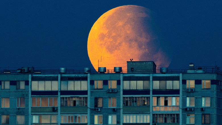 A partial lunar eclipse and harvest supermoon is seen during over the residential building in Moscow, Russia, September 18, 2024.