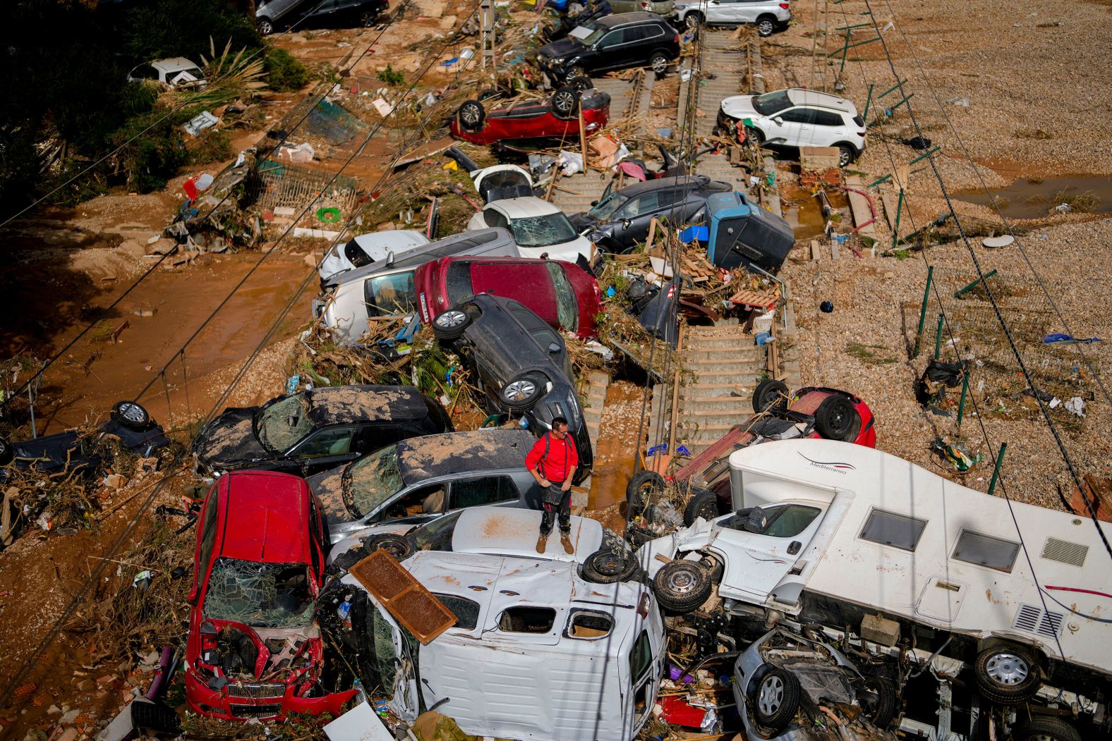 A man stands among damaged vehicles in Valencia, Spain, on Thursday, October 31. <a href="index.php?page=&url=https%3A%2F%2Fwww.cnn.com%2F2024%2F10%2F31%2Fworld%2Fgallery%2Fflash-flooding-spain%2Findex.html">Deadly flash floods</a> ripped across southern and eastern Spain, where some areas received up to 12 inches of rain in just a few hours. The majority of deaths are in the Valencia region, which saw its heaviest rainfall in 28 years.