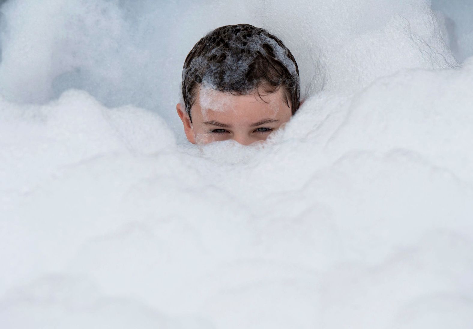 Emmett Quinto, 7, plays in a bubble station set up for children at the Woodward Dream Cruise, an automotive event in Ferndale, Michigan, on Saturday, August 17.