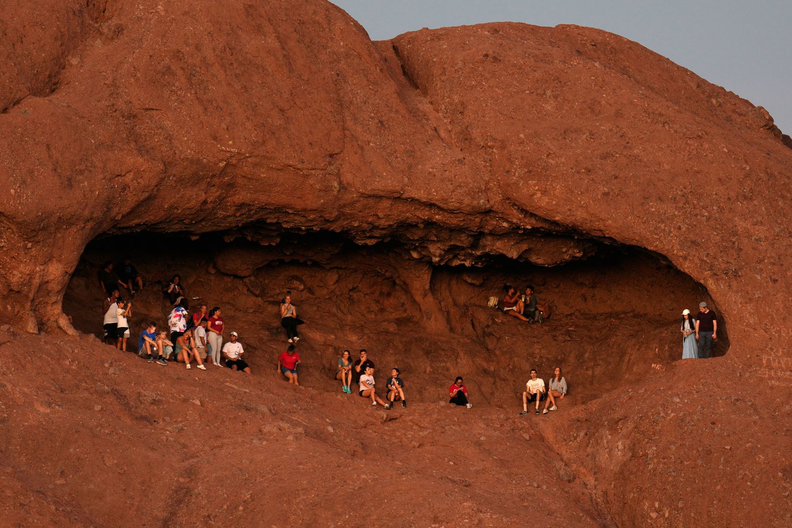 Hikers watch the sunset at the Hole in the Rock in Phoenix’s Papago Park on Monday, August 19.