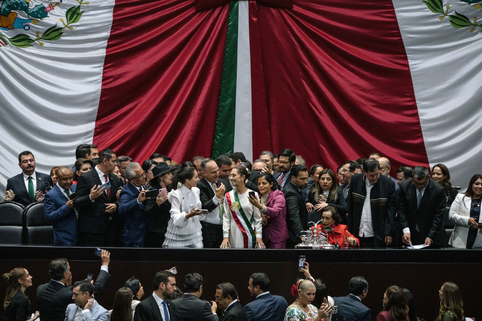Mexican President Claudia Sheinbaum, at center wearing the sash, is congratulated at <a href="index.php?page=&url=https%3A%2F%2Fwww.cnn.com%2F2024%2F10%2F01%2Famericas%2Fclaudia-sheinbaum-swearing-in-mexico-intl-latam%2Findex.html">her inauguration</a> in Mexico City on Tuesday, October 1. She is the country’s first female president.