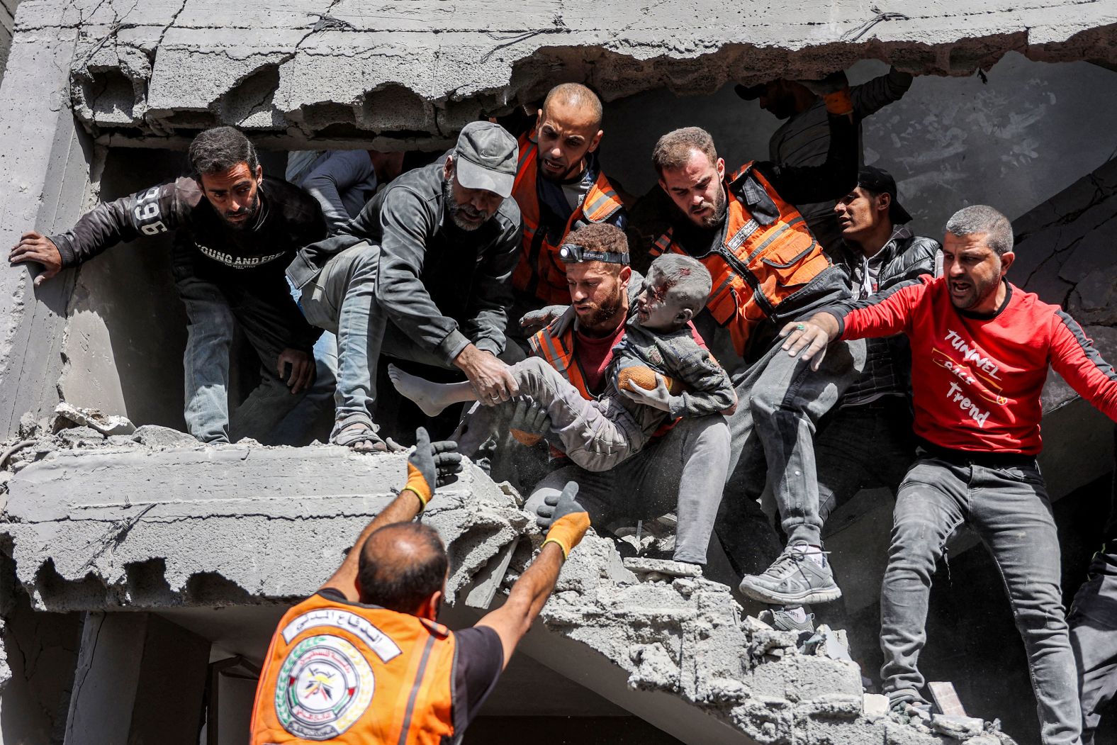 Palestinian civil defense members rescue a child from a Gaza City building that was bombed by Israel during its war against Hamas on Saturday, October 26.