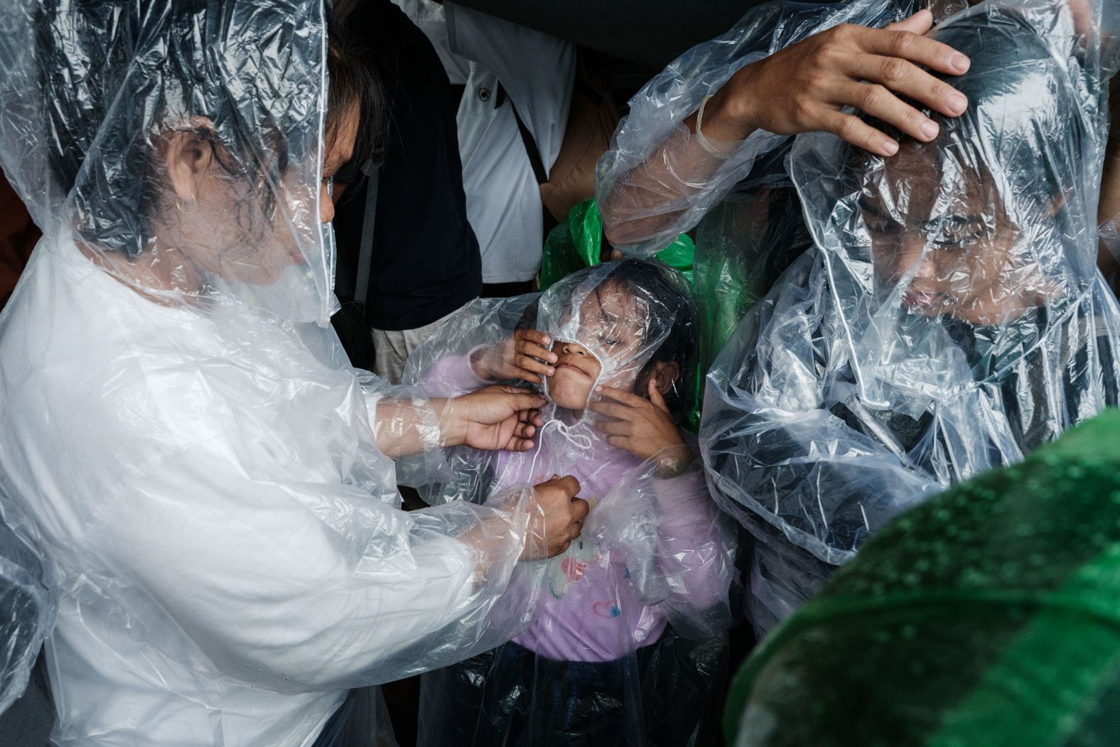 A family takes shelter from the rain during a protest on Indonesian National Farmers' Day in Jakarta, Indonesia, on Tuesday, September 24.