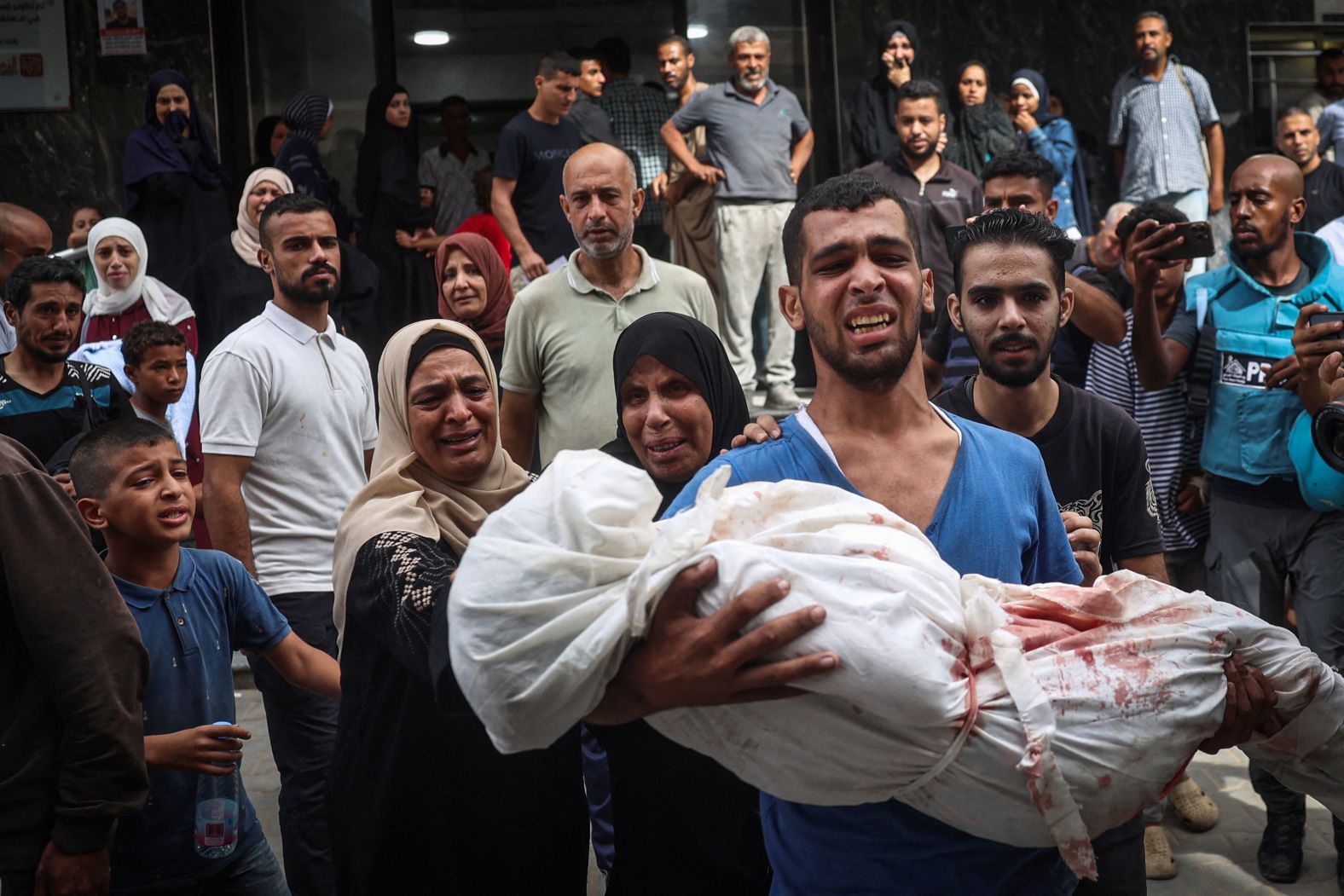 A Palestinian man carries the body of a relative who was killed in Israeli strikes on the Al Bureij refugee camp in Gaza on Tuesday, September 17.