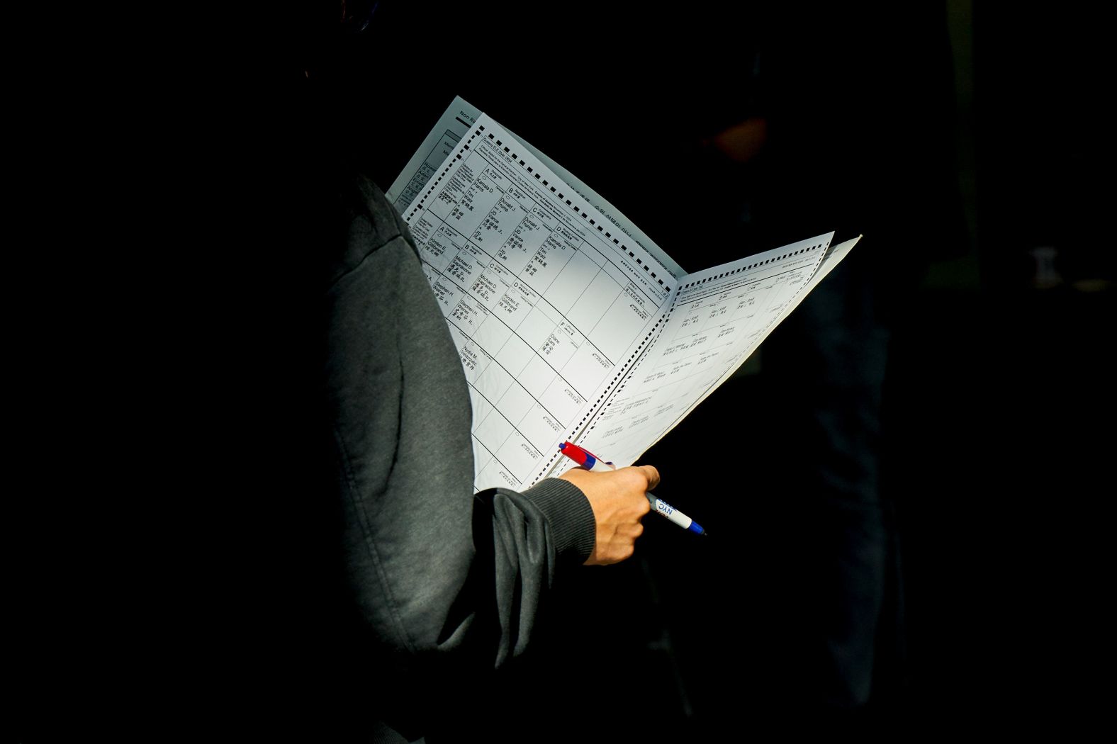 A woman looks at a ballot while in line for early voting in New York on Sunday, October 27.